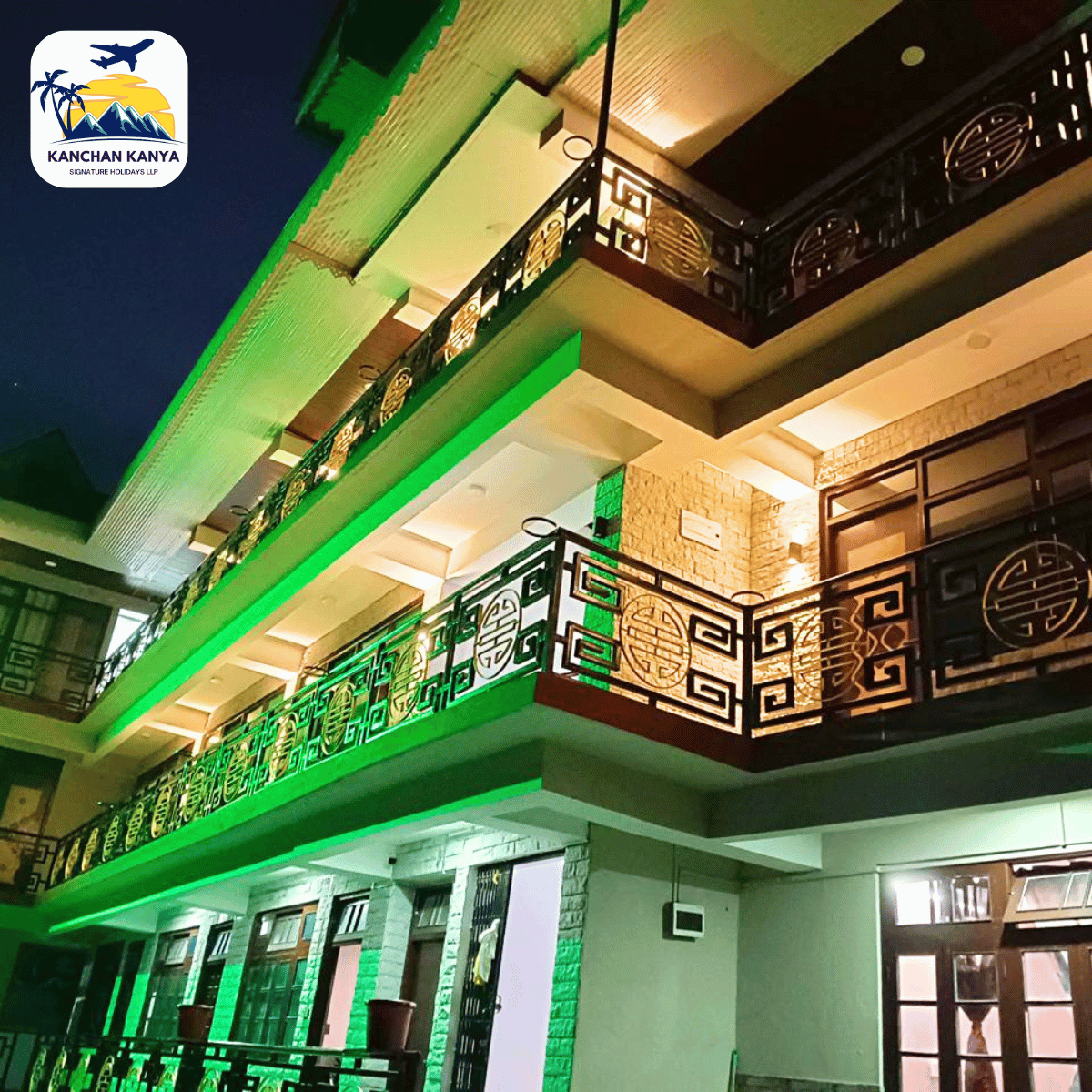 12 Evening view of a two-story building illuminated with green lights and decorative black railings; a logo in the top-left corner reads KANCHAN KANYA.