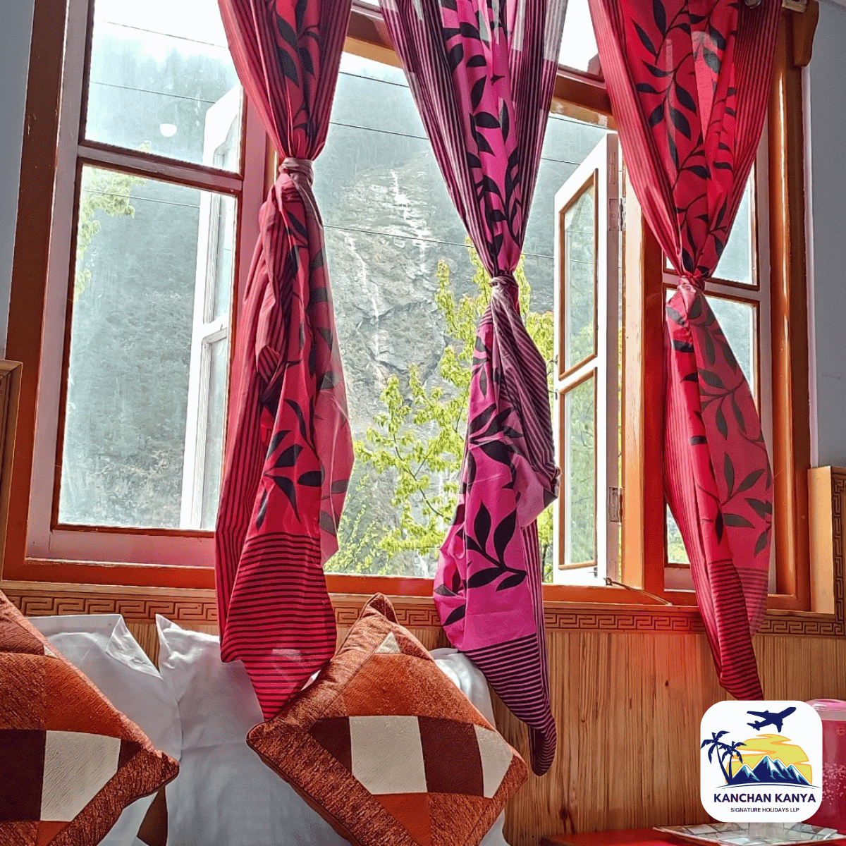18 Bright pink patterned curtains tied back at a window, with orange geometric cushions on a wooden bench.